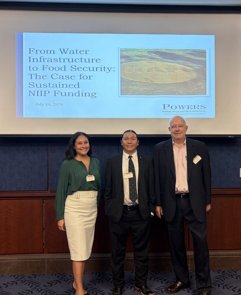 Natasha John, Lionel Haskie, and Paul Moorehead in front of their presentation slides